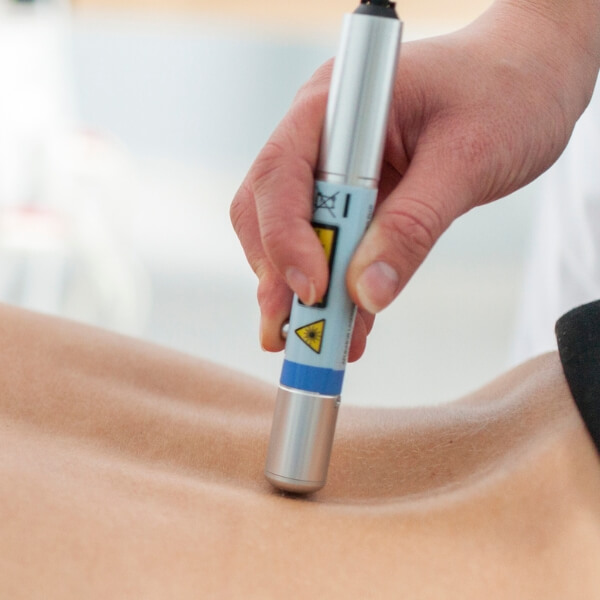 Therapist applying low level laser wand to a client's back